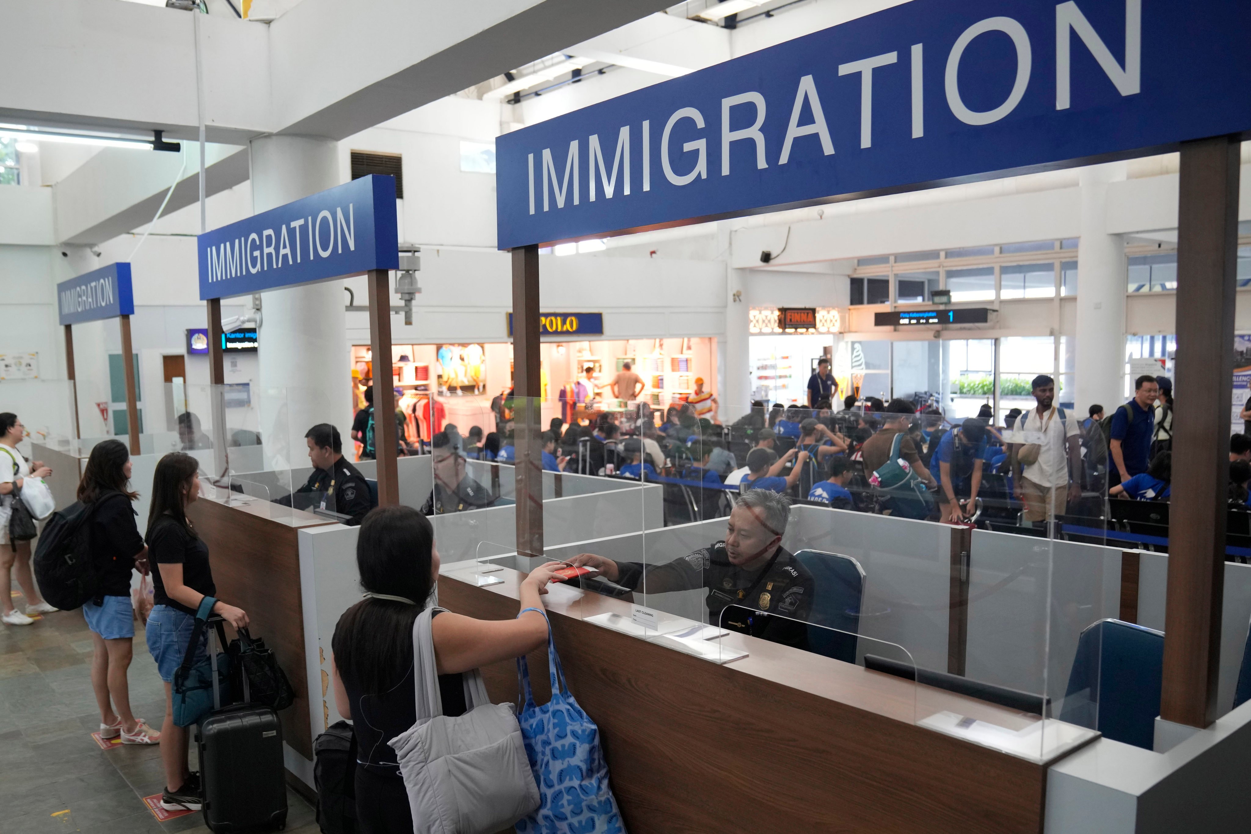 Immigration officers check passengers’ passports at a ferry terminal on Indonesia’s Bintan Island in May. Photo: AP